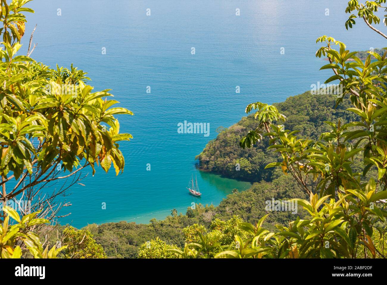 Ilha Grande, Brasilien. 24. Dezember, 2012. Atemberaubende Aussicht auf Enseada Santorini Santorini (Bay) und Segelboot vor der Küste vor Anker aus Vila do Santorini Santorini (Dorf), von der Spur Suche während der wunderschönen sonnigen Tag, Sicht auf dem Weg in Palmas, die Ilha Grande (Grosse Insel), die Gemeinde von Angra dos Reis, Bundesstaat Rio de Janeiro, Brasilien. Am 5. Juli 2019, Ilha Grande wurde von der UNESCO als Weltkulturerbe eingetragen. Stockfoto