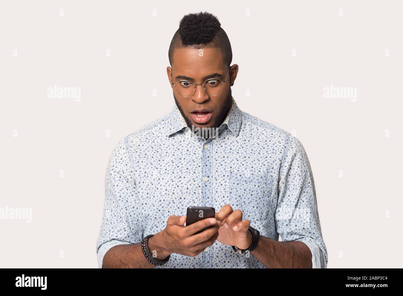 Afrikanische amerikanische Mann am Telefon mit offenen Mund Staunen Stockfoto