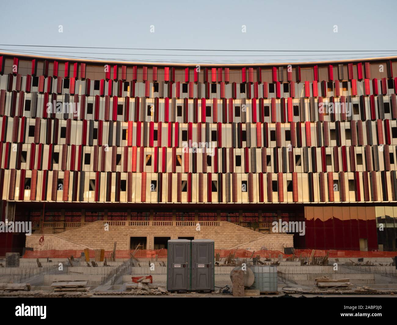 Tirana, Albanien - 30. September 2019: in der Nähe von Rot und Braun Metall- und Glasfassade der Luft Albanien Stadion mit laufenden Bau Projekt i Stockfoto