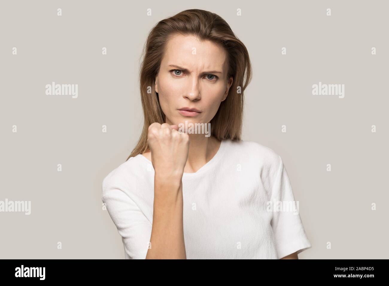 Wütende junge Frau, geballte Faust an Kamera, Warnung Stockfoto