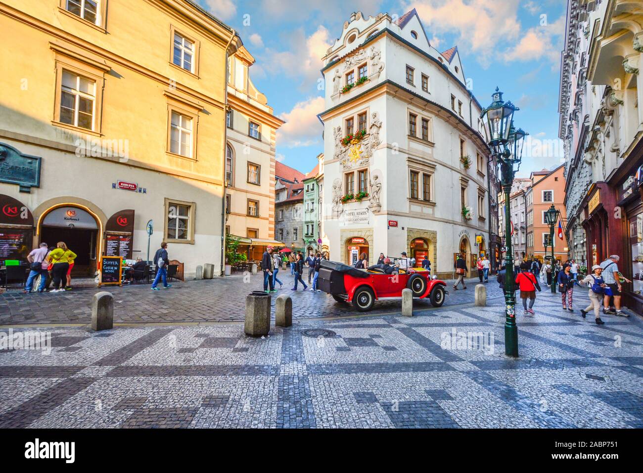 Touristen Sightseeing, Einkaufen und die Cafés genießen, wie Sie von einem alten roten Auto in einem malerischen Teil der Altstadt Prag, Tschechische Republik. Stockfoto
