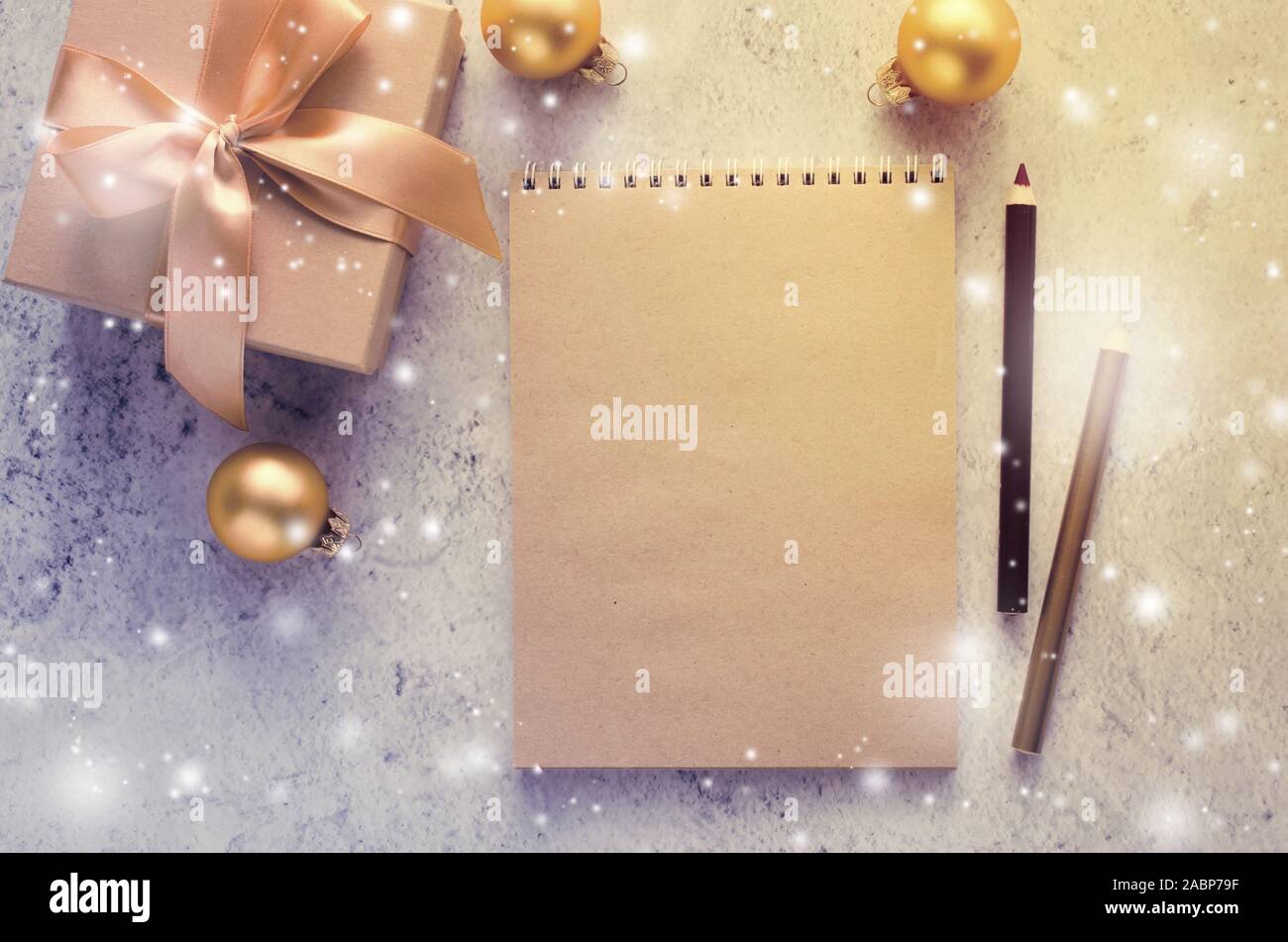 Weihnachten Hintergrund mit leeren braun Notebook und Geschenkbox im Vintage Stil. Weihnachten mock up für Grußkarte oder Brief an Santa. Schnee Effekt. Cop Stockfoto