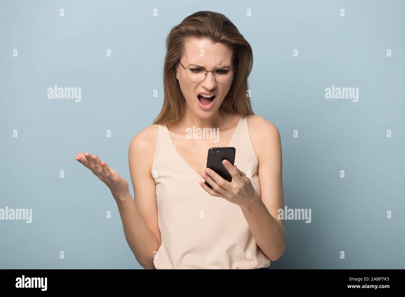Unglücklich wütende Frau mit Phone, lesen schlechte Nachrichten Stockfoto