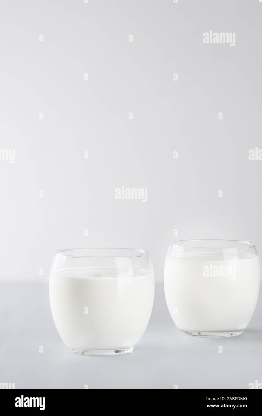 Organische probiotischen Milch kefir Drink oder Joghurt in zwei Gläser. Fermentierte Milch trinken. Bild mit Kopie Raum, vertikale Ausrichtung. Stockfoto