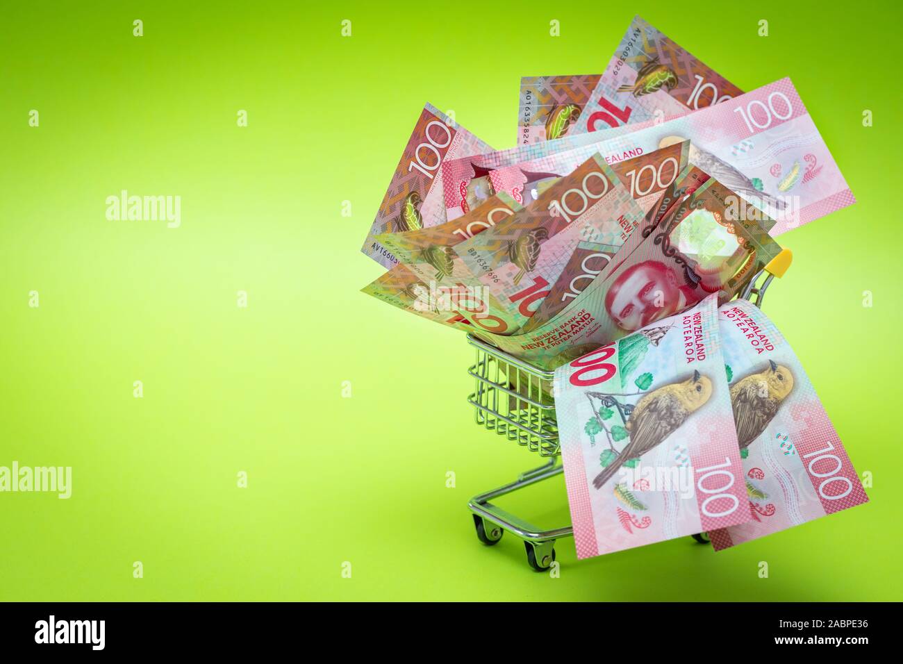 Miniatur Einkaufswagen mit Neuseeland Hundert-Euro-Scheine. Das Konzept der Shopping- und die Kraft der Wirtschaft Stockfoto