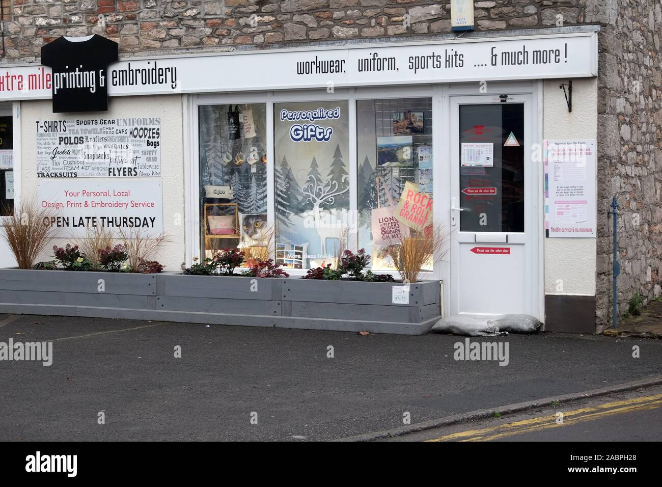 November 2019 - Kleines Dorf Shop Verkauf von Berufsbekleidung und embrobery im Somerset Village von Cheddar Stockfoto