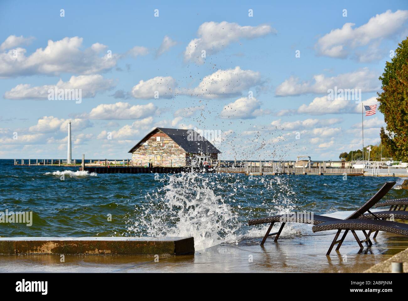 Wellen, die auf der Station mit den Gartenstühlen Nass bei starkem Wind im Herbst, Anderson Dock Lager mit Graffiti Entfernung, Ephriam, WI, USA Stockfoto