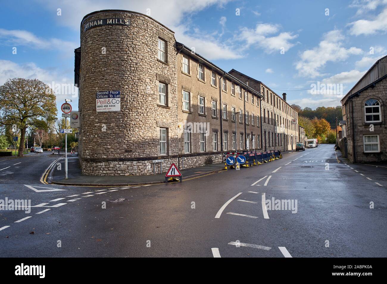 Alte steinerne Lagerhäuser an Aynam Mühlen, Canal Leiter, Kendal, Cumbria, Großbritannien mit Bauarbeiten Schilder Stockfoto