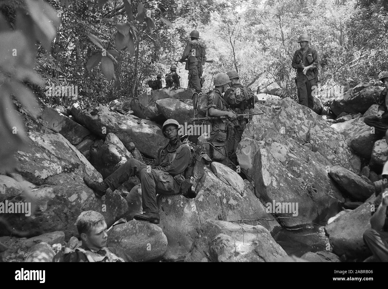 Marines von Unternehmen L, 3rd Battalion, 5th Marines, nehmen Sie einen Rest auf felsigem Gelände in der Nähe von Dong Ha während des Betriebs Hastings in Vietnam, Juli 1966. Stockfoto