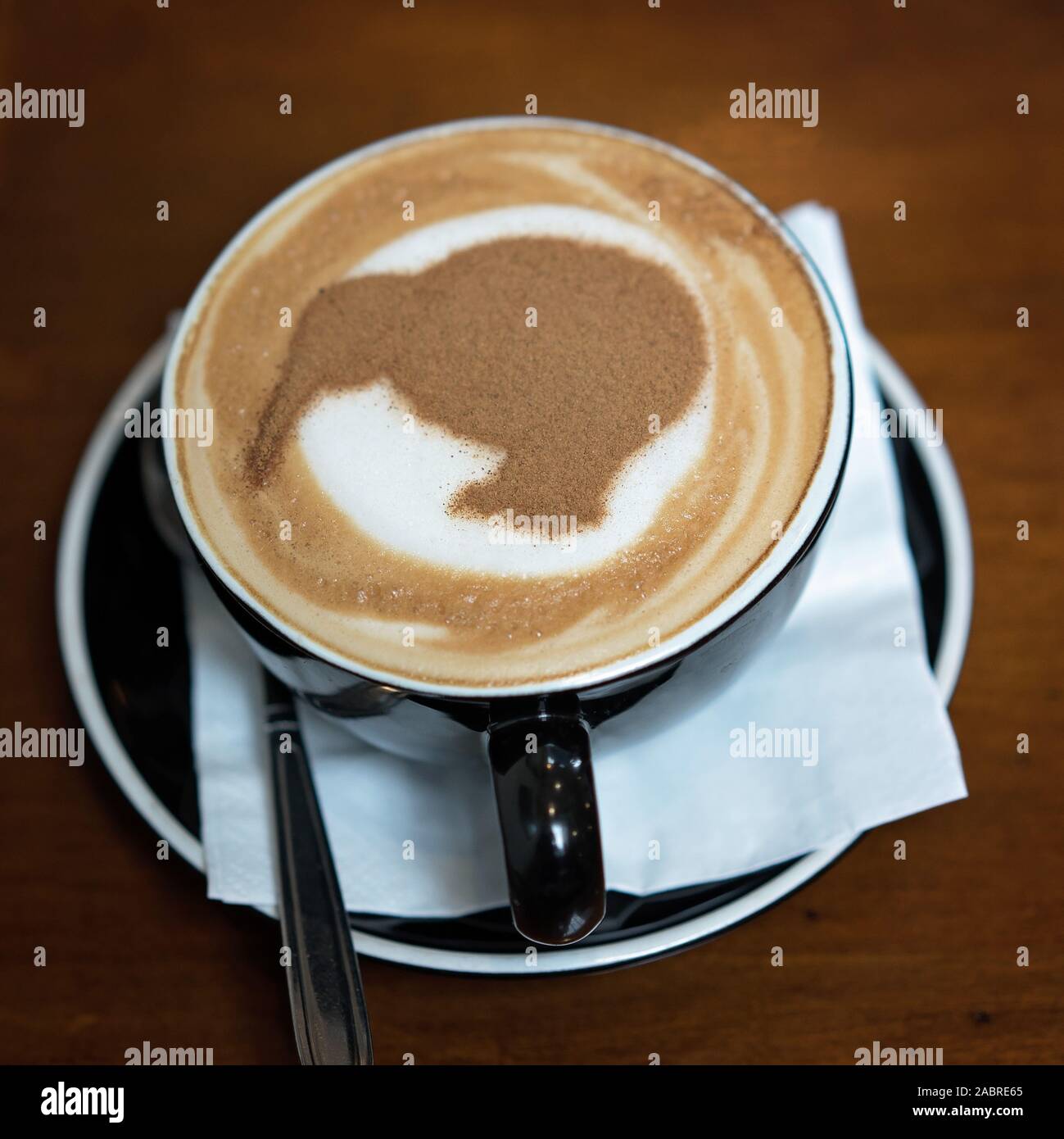 Eine Tasse Cappuccino mit einer Kiwi in Schokolade besprüht, Neuseeland Stockfoto