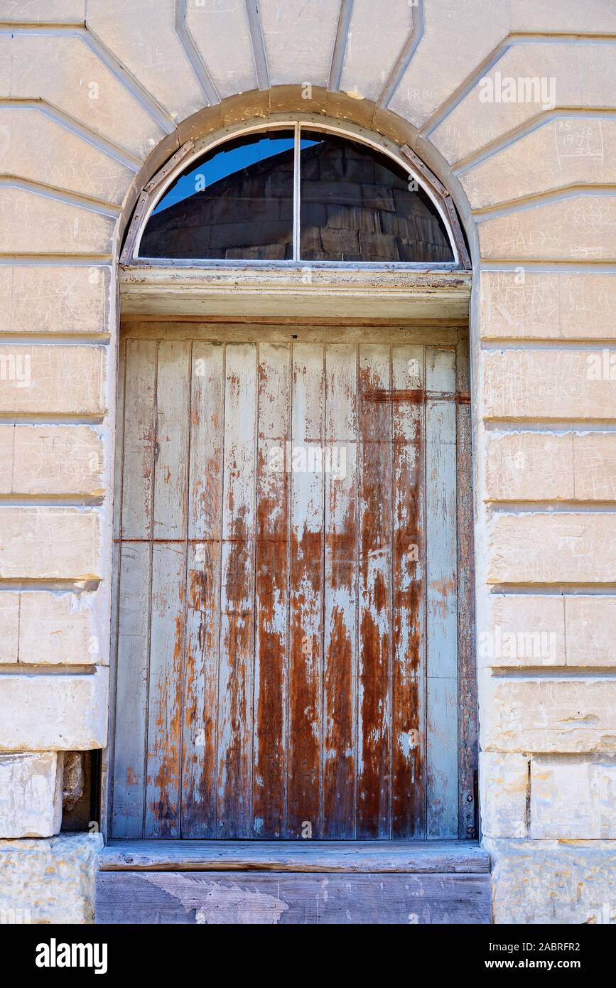 Eine alte hölzerne Tür, in einem verlassenen Backsteinlagerhauses Stockfoto