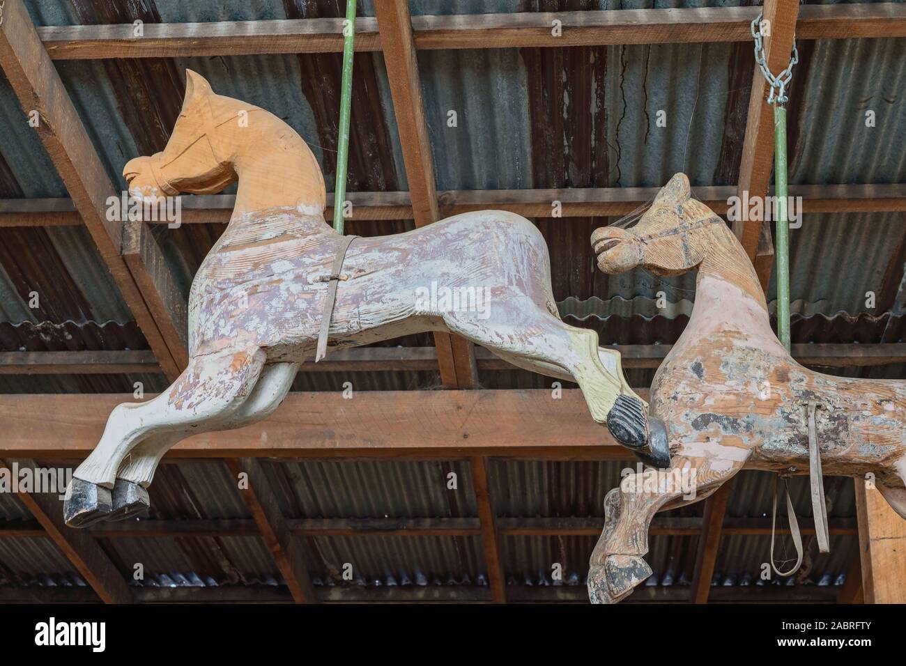 Verlassenes Karussell Pferde, die von der Decke hängen von einem alten Lagerhaus Stockfoto