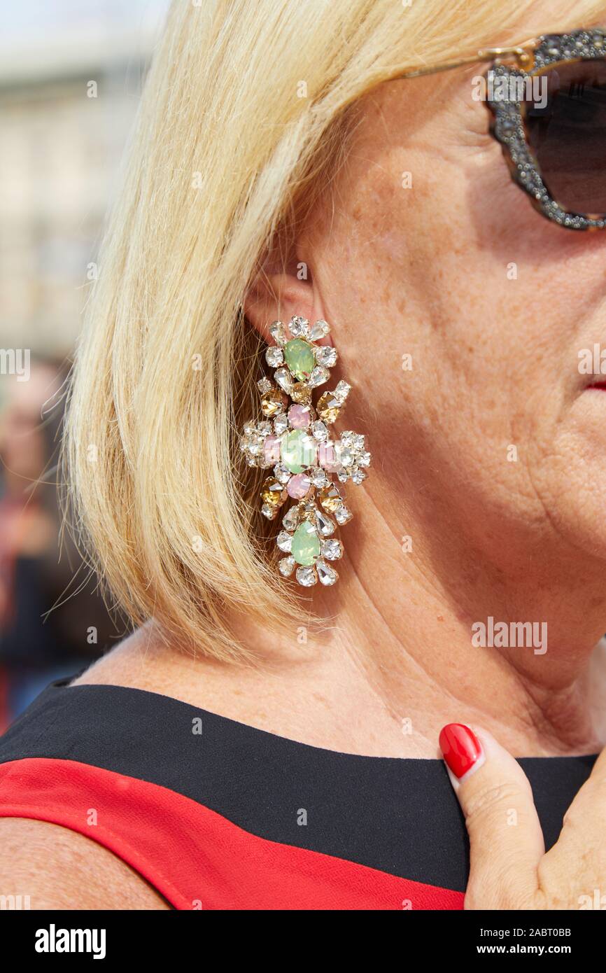 Mailand, Italien - 18 SEPTEMBER 2019: Frau mit Kreuz Ohrring mit Grün und Pink Edelsteine vor Tiziano Guardini fashion show, Mailand Fashion Week Straße s Stockfoto