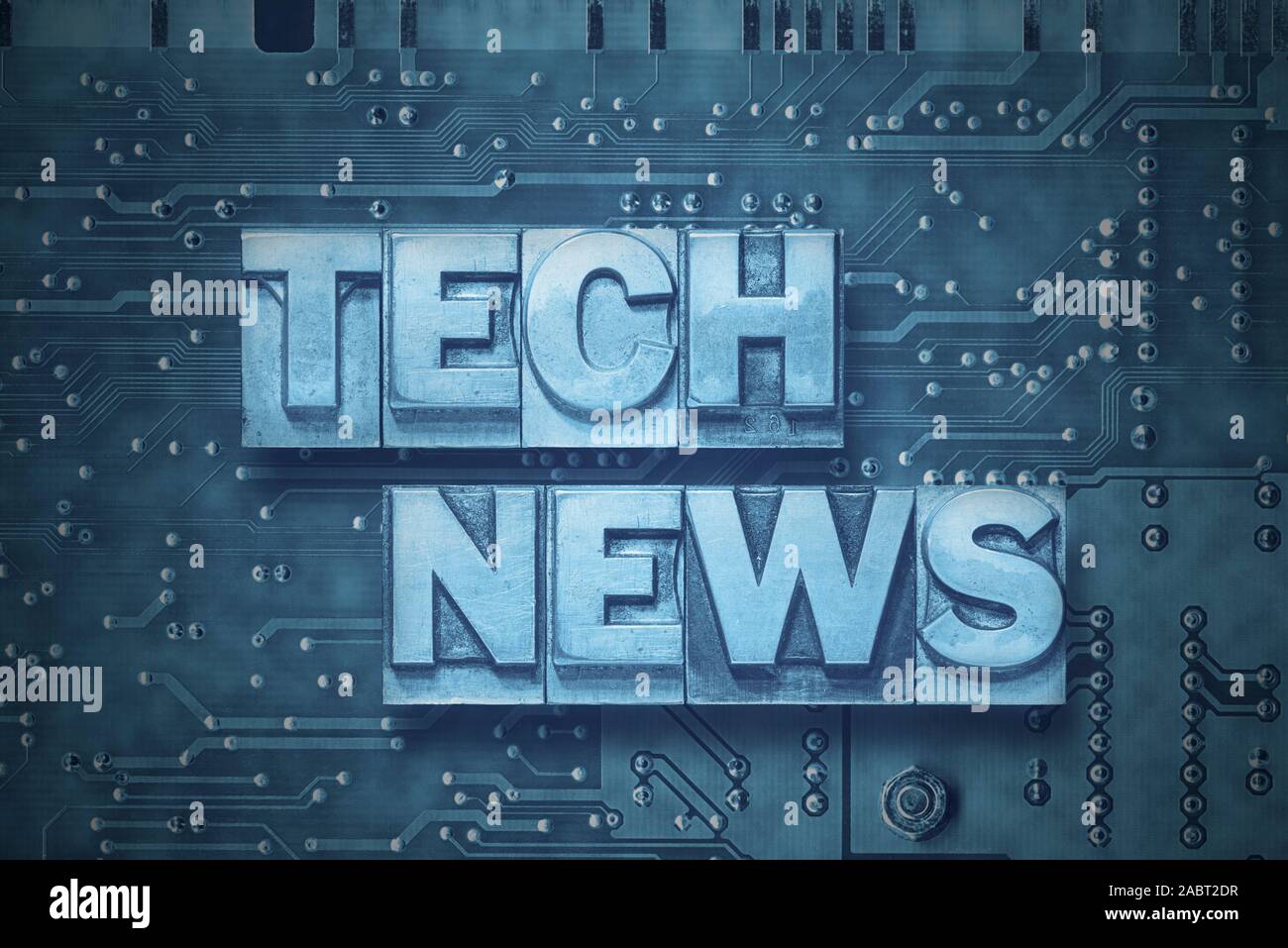 Tech News Phrase von metallischen Buchdruck Blöcke, die auf der PC-Platine Hintergrund Stockfoto