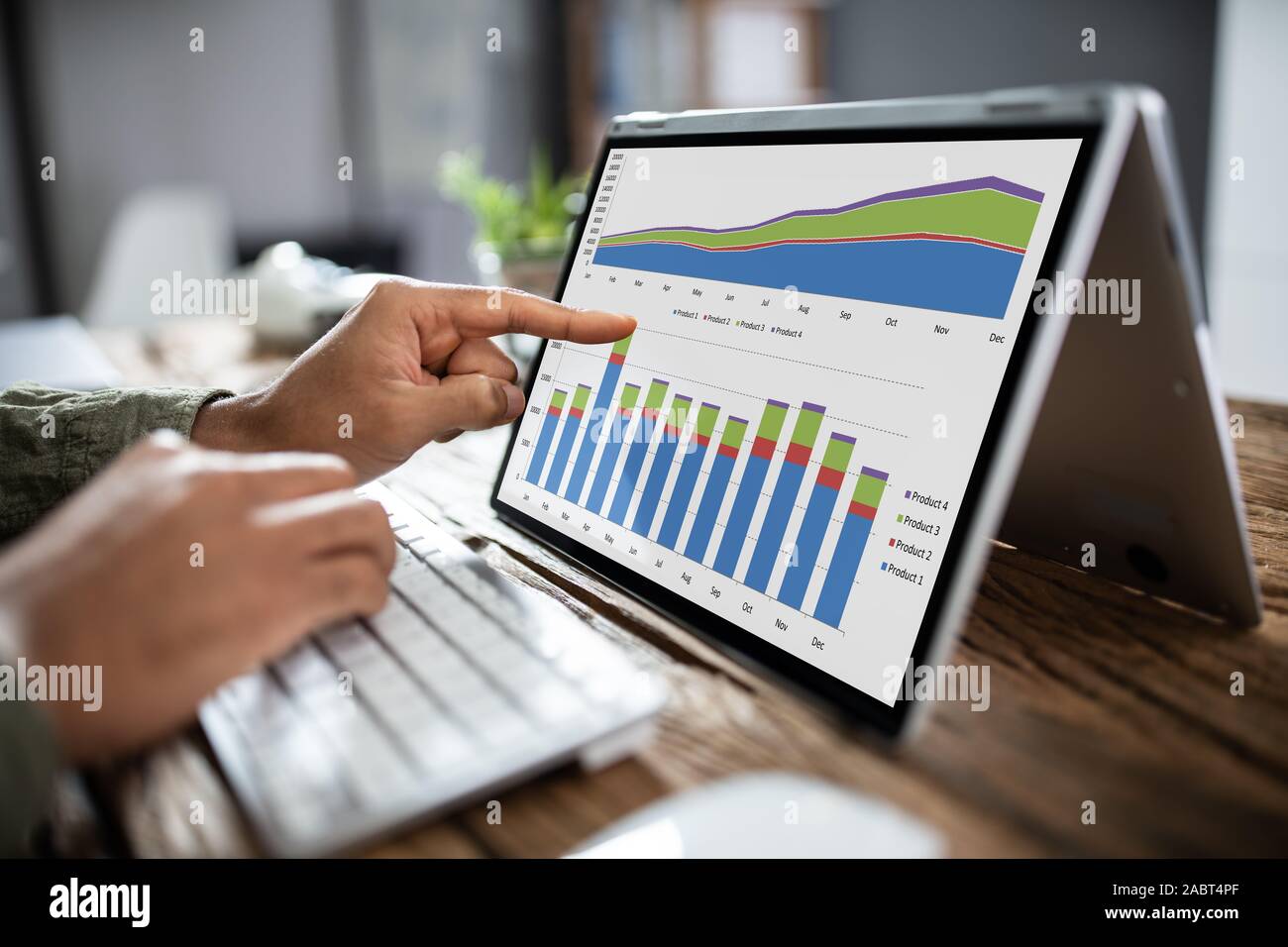 In der Nähe von einem Geschäftsmann Hand Analyse von Graphen auf Laptop am Arbeitsplatz Stockfoto