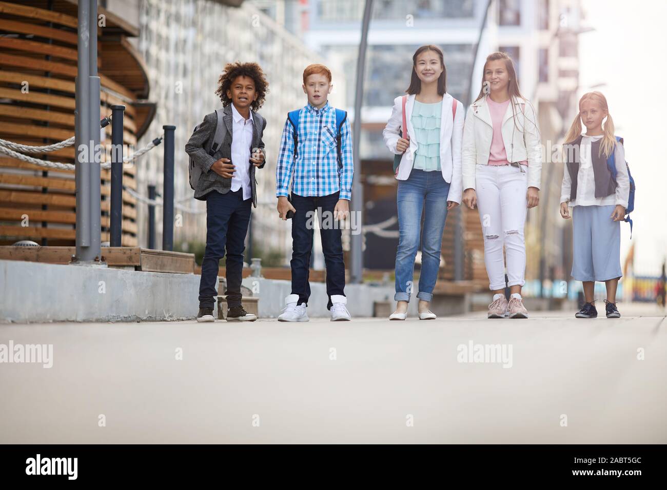 Gruppe von Multiethnischen zusammen Kinder zu Fuß entlang der Straße im Sommer Tag Stockfoto