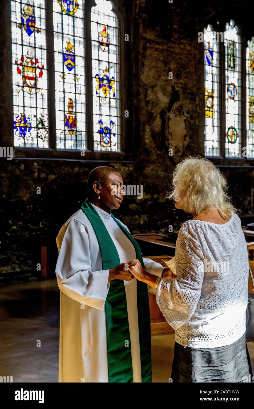 Anglikanische Priesterin Rose Hudson-Wilkin gruss Gemeindemitglieder in All Hallows durch den Turm, die älteste Kirche in der Stadt von London. Großbritannien Stockfoto