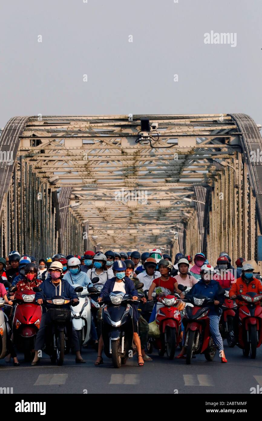Motorroller Überquerung der berühmten Trang Tien Brücke im morgendlichen Berufsverkehr. Farbton. Vietnam. Stockfoto