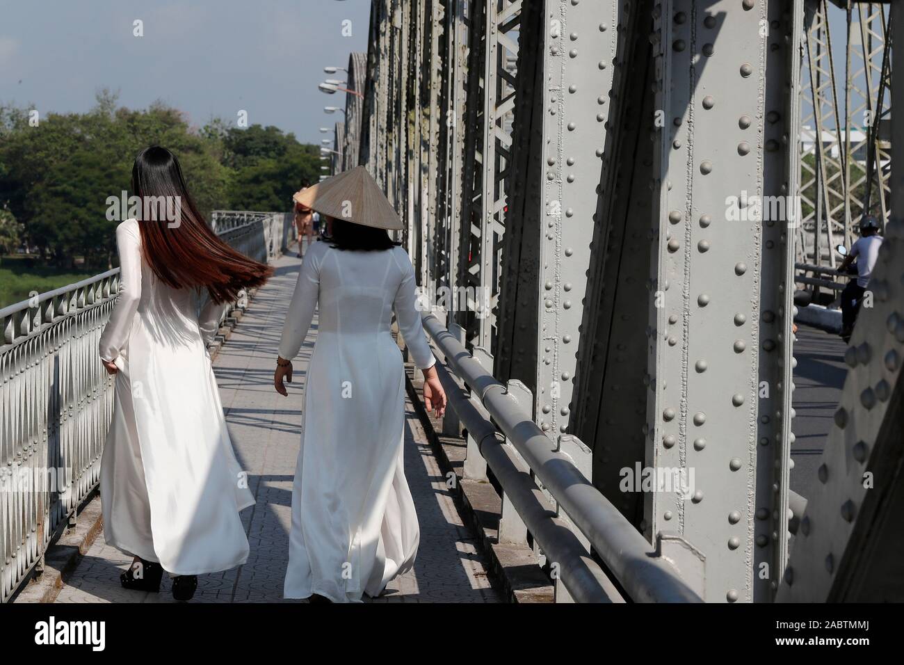 Vietnamesische Frauen, Ao Dai zu Fuß auf den berühmten Trang Tien Brücke. Farbton. Vietnam. Stockfoto