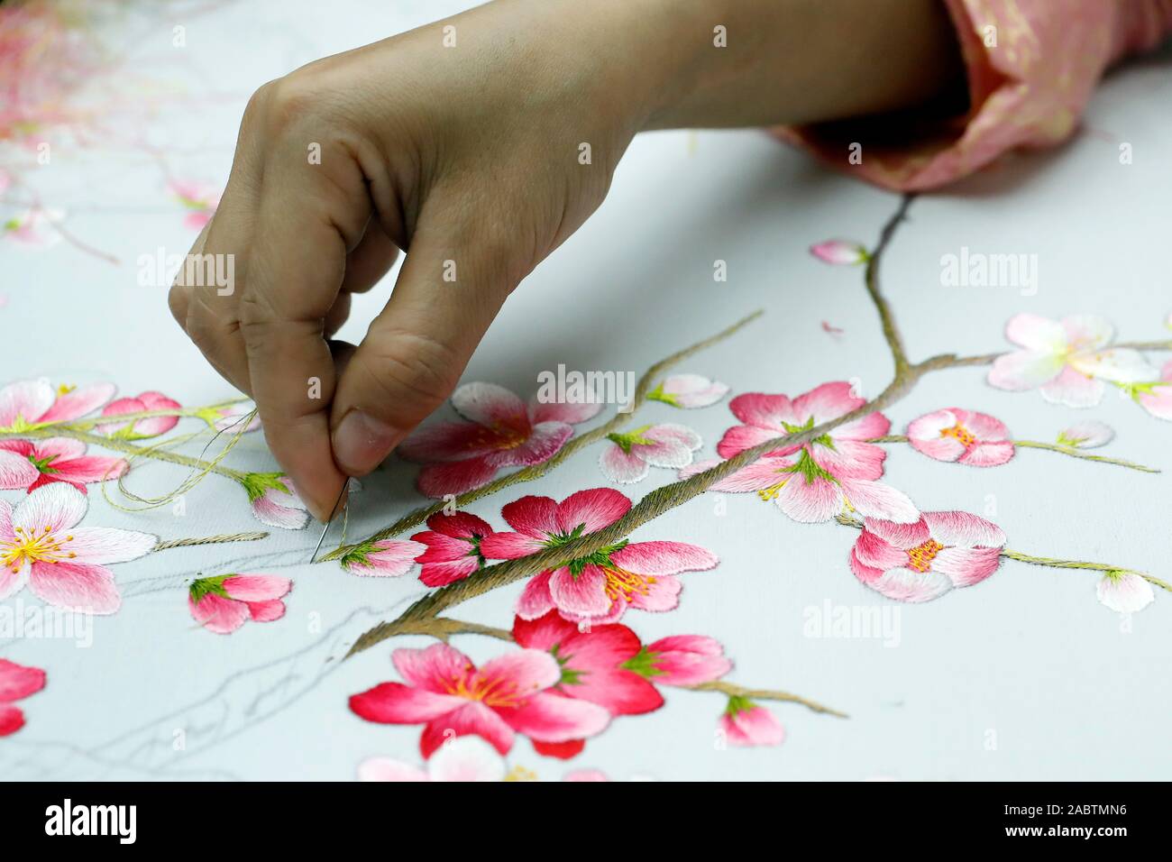 Junge weibliche Arbeitnehmer tun Stickerei. Blumen. Close-up auf der Hand. Farbton. Vietnam. Stockfoto