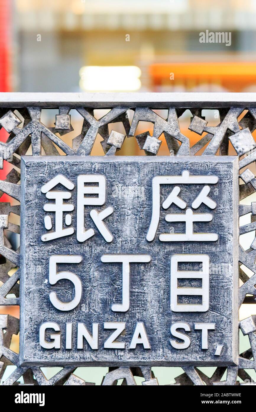 Tokyo, Ginza. Kleine Zeichen auf Bürgersteig, Gehweg Geländer, sowohl in japanischer Kanji script und Englisch, Ginza St. Stockfoto