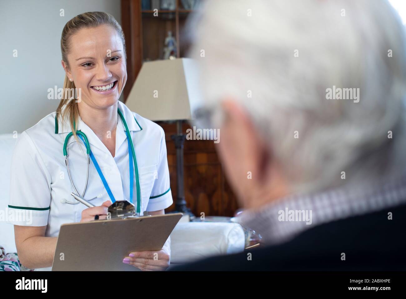 Krankenschwester, Medizinische Anmerkungen vom älteren Mann zu Hause auf Besuch Stockfoto