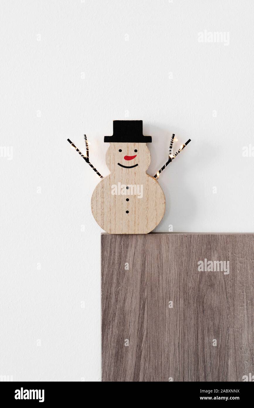 Eine lustige Holz Schneemann, mit einer roten Nase und einen Hut tragen, gegen einen weißen Hintergrund mit einigen leeren Raum auf der Oberseite Stockfoto