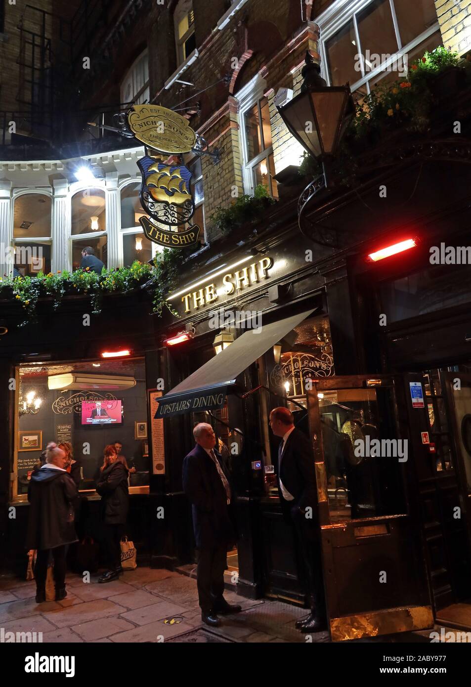 The Ship,11 Talbot Court,City of London,South East,England,UK,EC3V 0BP, Nicholsons Pub bei Nacht,mit Leuten die trinken Stockfoto