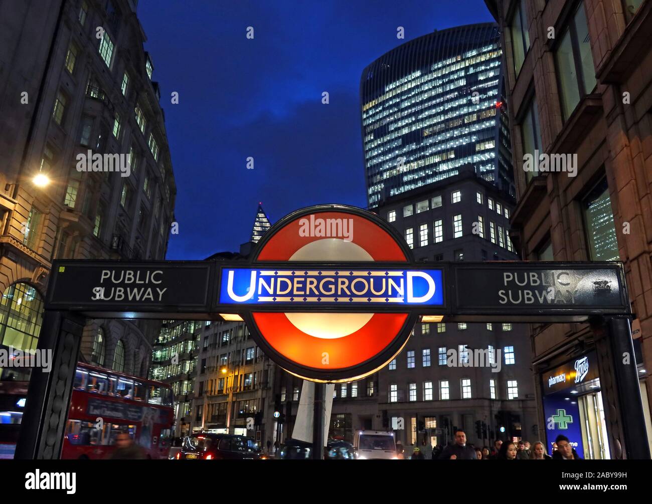 TfL London U-Bahn-Schild im alten Stil, in der Abenddämmerung in der City of London, Bank Tube Station, City of London Financial District hinter, England, Großbritannien Stockfoto