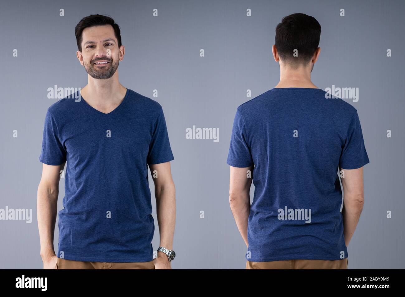 Mann im blauen T-Shirt stand auf grauem Hintergrund Stockfoto