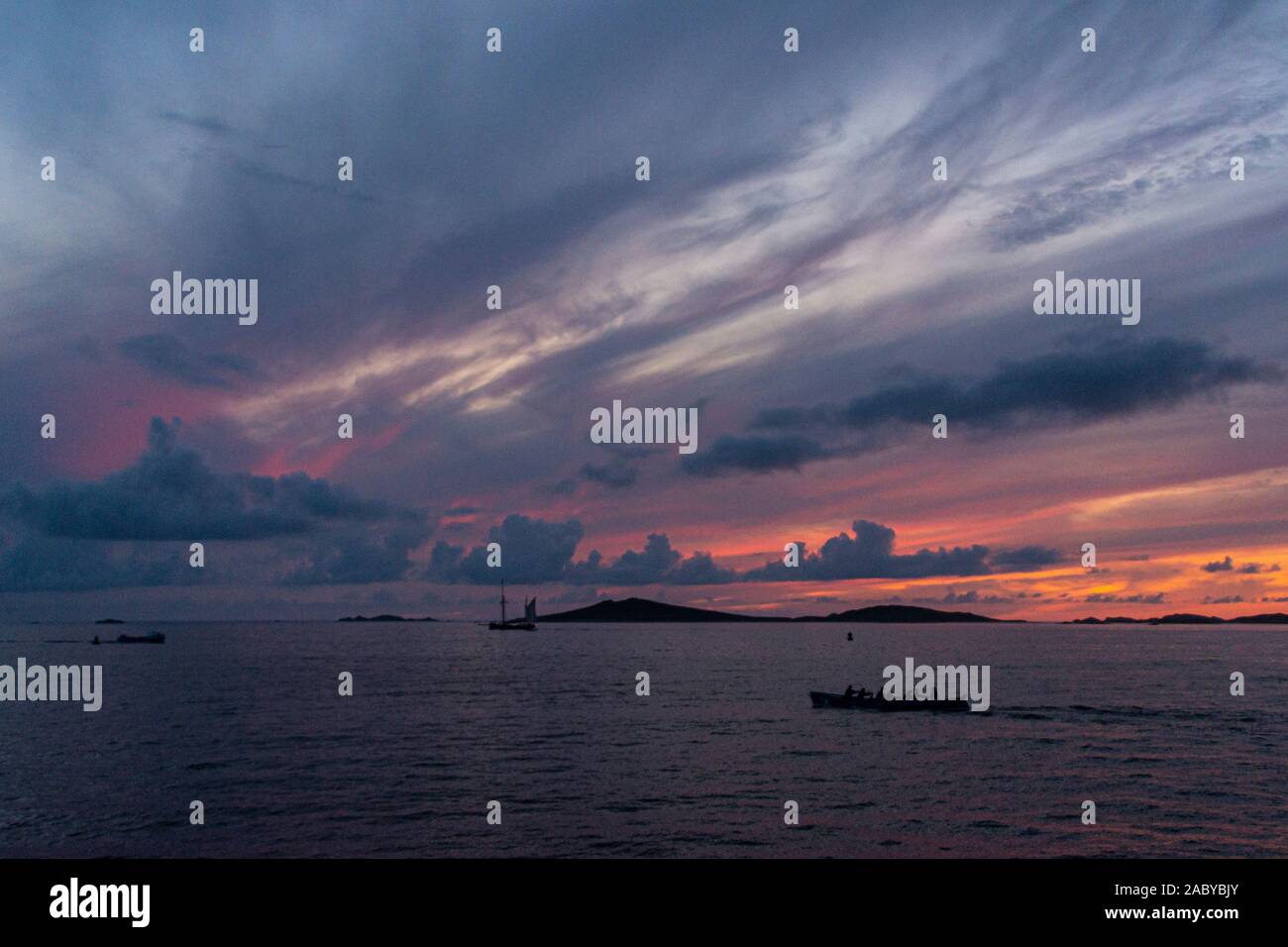 Ein kornisches Pilot gig Boot gerudert wird zwischen den Scilly-inseln bei Sonnenuntergang Stockfoto