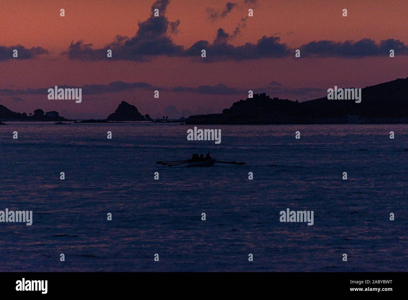 Ein kornisches Pilot gig Boot gerudert wird zwischen den Scilly-inseln bei Sonnenuntergang Stockfoto