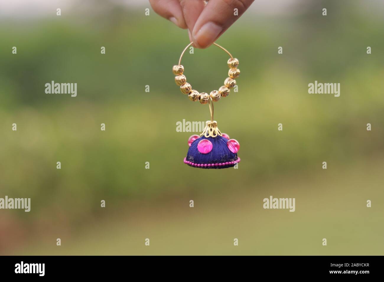 Die Hand, bunte Ohrringe mit verschwommenen Hintergrund Stockfoto