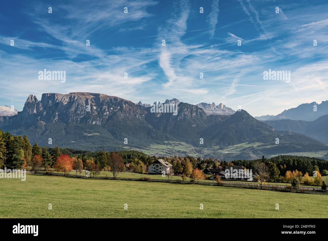 Panoramablick auf den Schlern Bergmassiv und das Dorf Voels am Schlern in Südtirol von den Ritten an einem strahlenden Herbsttag gesehen Stockfoto