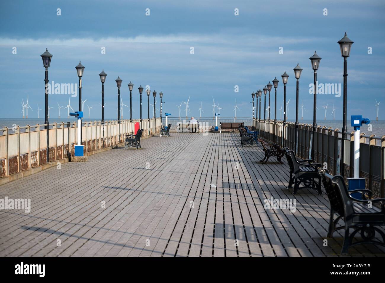 Im mittleren Alter Mann saß auf einer Bank am Ende der Skegness Pier in der traditionellen Küstenstadt Skegness, Lincolnshire, Großbritannien Engand. Stockfoto