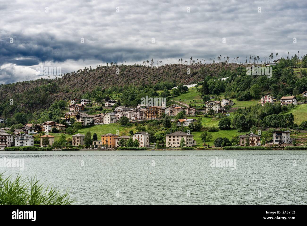 Serraia See (Lago della Serraia) und die kleine Stadt von Baselga di Pine mit der Bäume vom Wind im November 2018 gefallen. Trentino, Italien Stockfoto