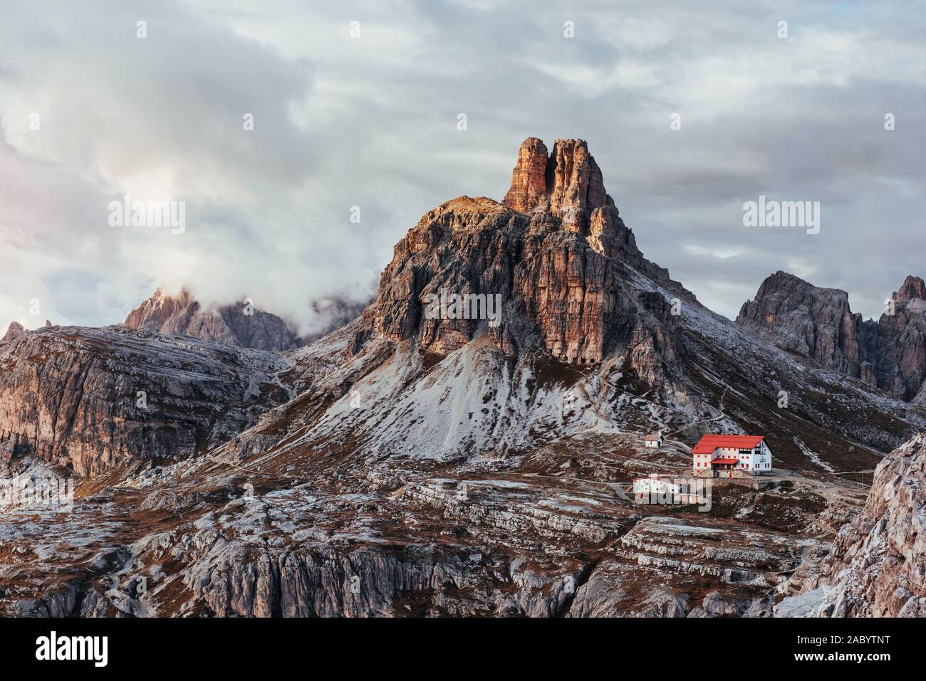 Berge der Paternkofel mit Nebel und Wolken am oberen und Gebäude auf der rechten Seite Stockfoto