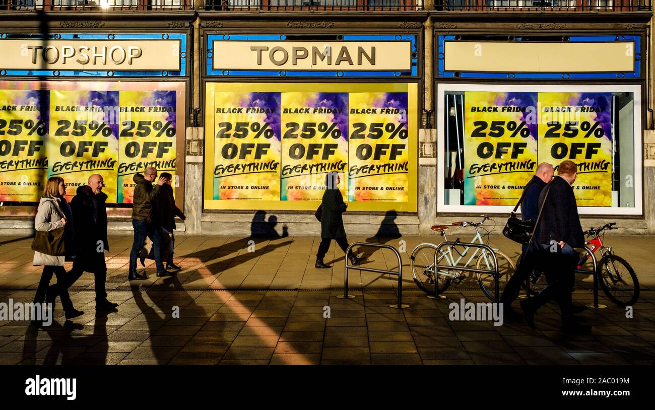 Menschen zu Fuß vorbei" Poster Black Friday' in einem Schaufenster in der Princes Street, Edinburgh am 29. November 2019 Stockfoto