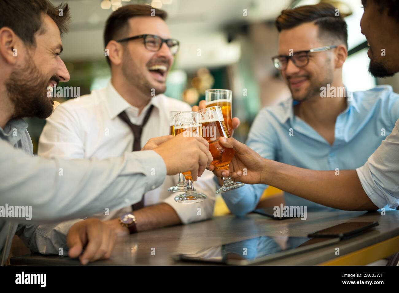 Geschäftsleute sitzen in der Kneipe und trinken Bier nach der Arbeit Stockfoto