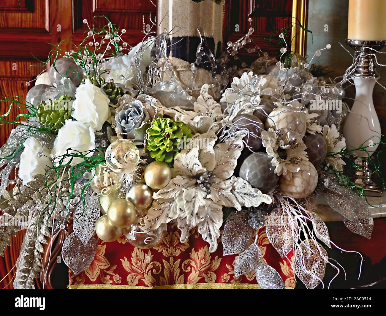 Üppige überhängenden Weihnachten Dekoration in einer Shell in Silbrigen Farbtönen und Perlmutt mit Kugeln, weiße Rosen, silbrigen Blätter, Gräser und Hellgrün Stockfoto