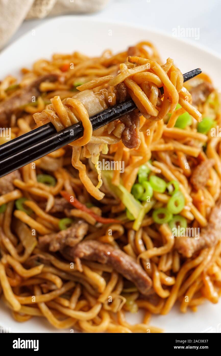 Essen chinesisch Rindfleisch lo mein Nudeln mit Stäbchen Stockfoto