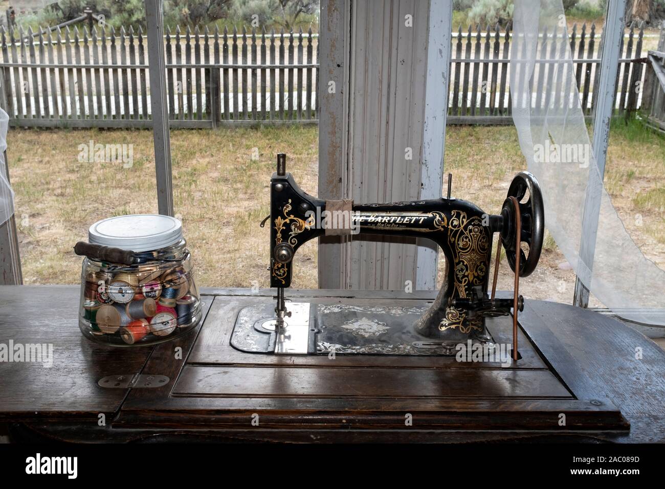 MT 00345-00 ... MONTANA - Nähmaschine und Glas mit Gewinde an im Bannack State Park, Beaverhead County. Stockfoto