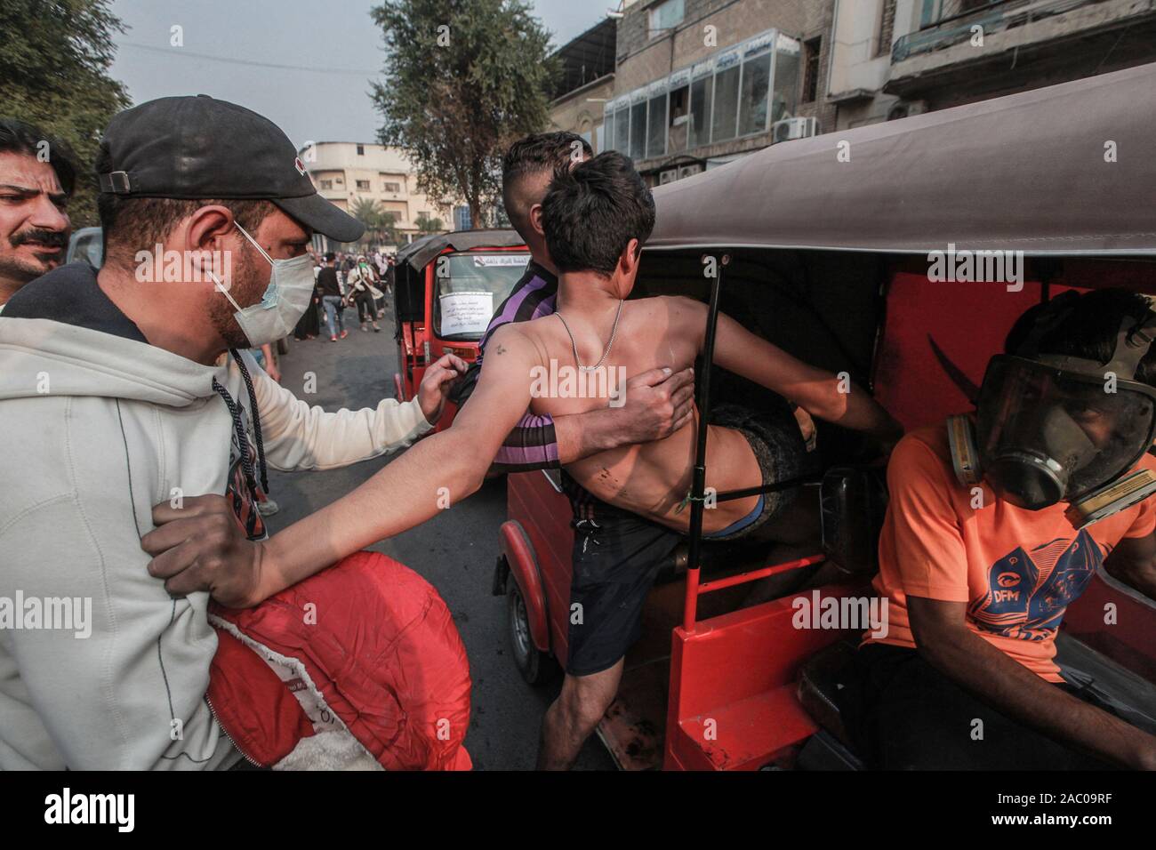 Bagdad, Irak. 29 Nov, 2019. Ein Mann trägt ein verletzter Demonstrant bei einem gewalttätigen Demonstration gegen die Regierung auf Al Rasheed Straße. Credit: Ameer Al Mohammedaw/dpa/Alamy leben Nachrichten Stockfoto