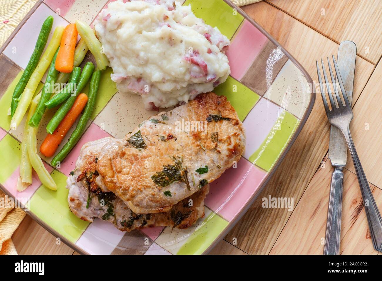 Salbei und Rosmarin BBQ Schweinekoteletts mit Haut - auf Kartoffelpüree und grünen Bohnen Stockfoto