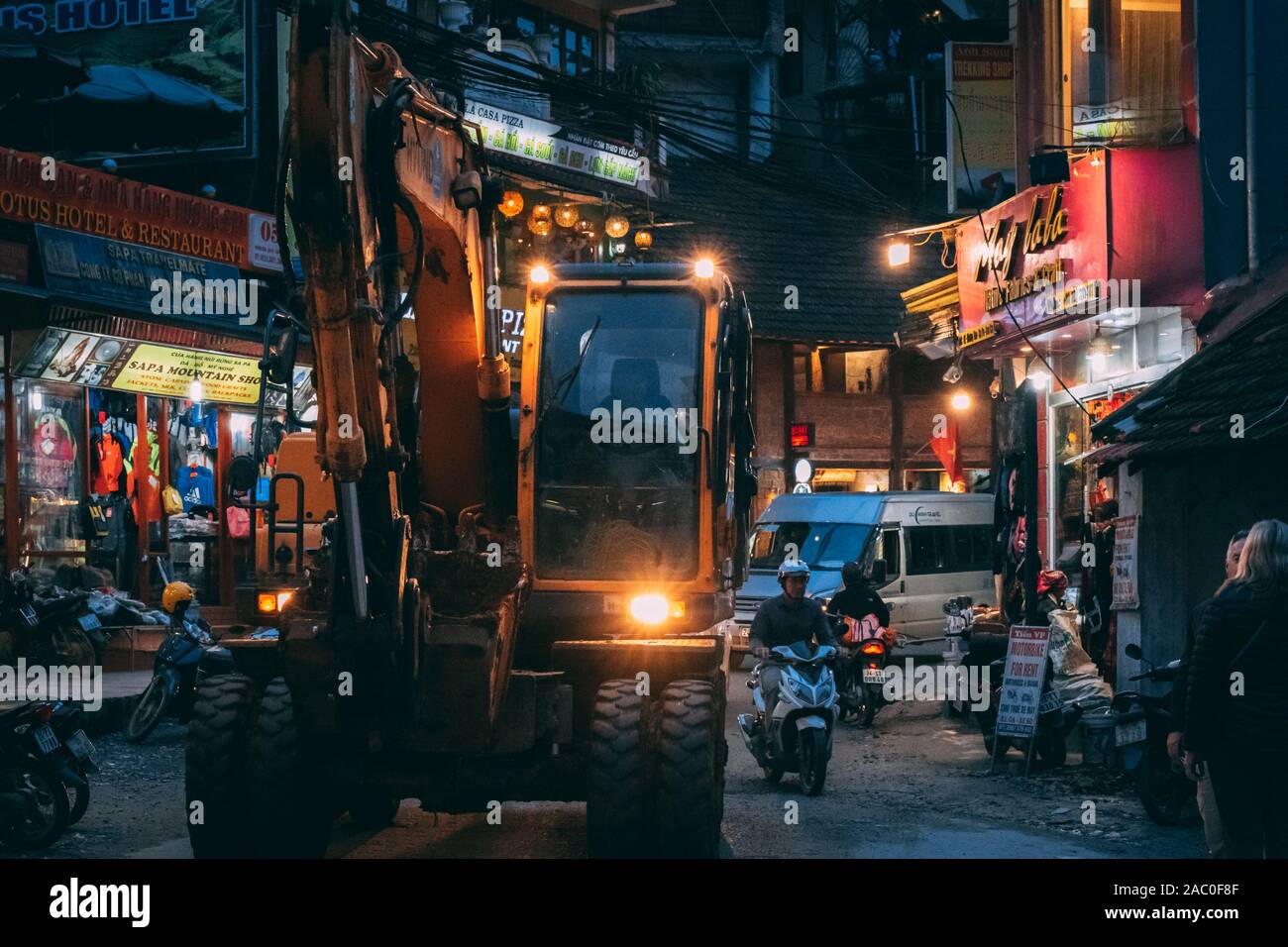 Sapa, Vietnam - 8. Oktober 2019: Bagger fahren durch die engen Gassen von Sapa während der Nacht als Sie erweitern und die touristische Stadt entwickeln. Stockfoto