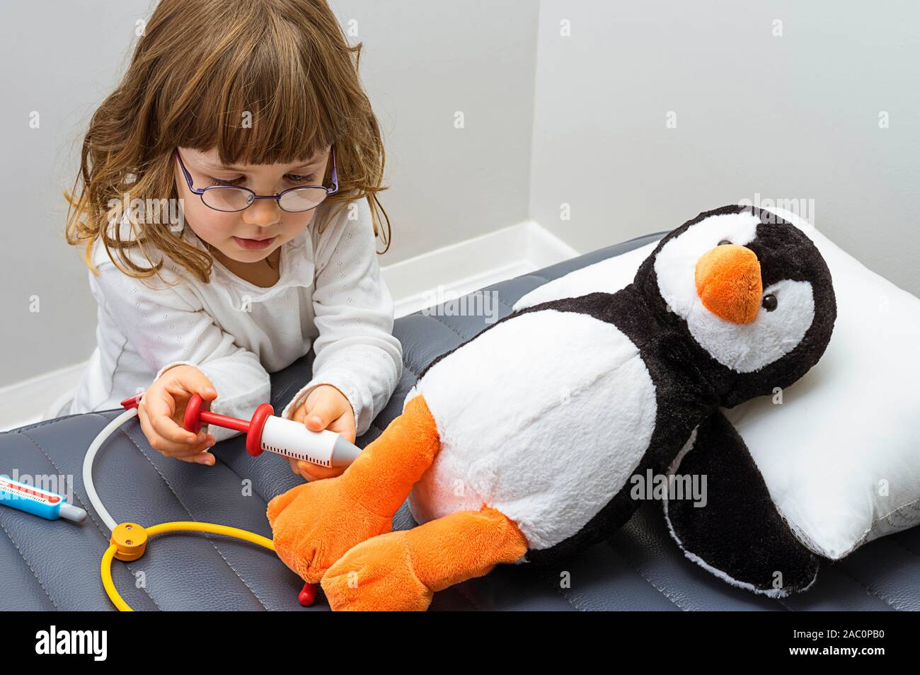 Kind, Mädchen spielen Arzt mit einem Spielzeug. Die Rettung der bedrohten Tiere. Beruf und Pflege Konzept. Neutrale Hintergrund. Stockfoto