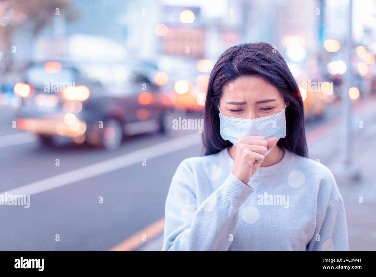 Junge Frau tragen Maske in der Stadt bei Smog Tag Stockfoto