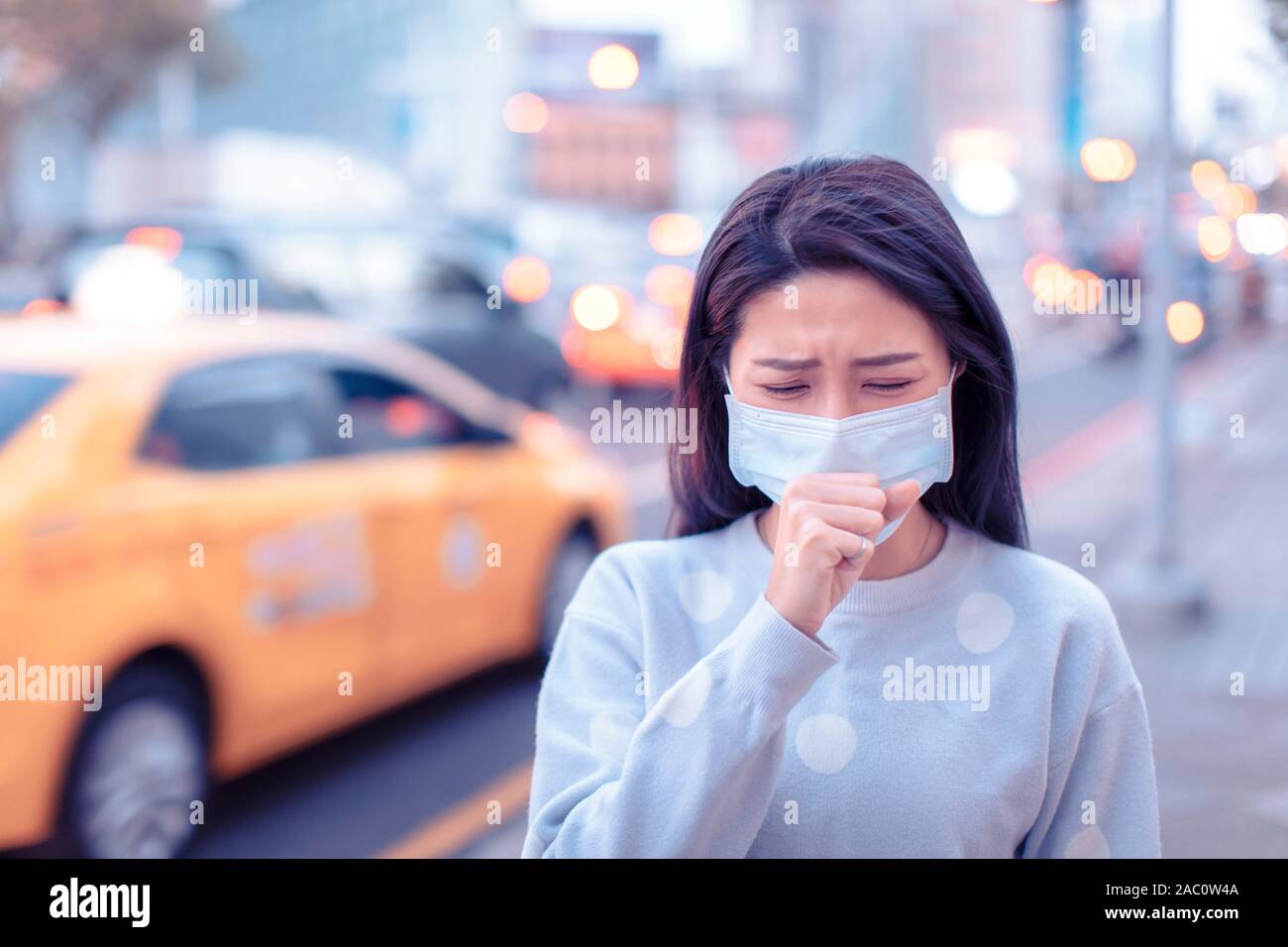 Junge Frau tragen Maske in der Stadt bei Smog Tag Stockfoto
