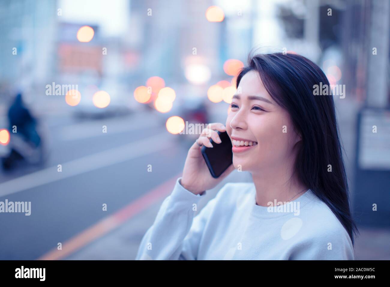 Junge Frau zu Fuß auf die Straße und am Telefon sprechen Stockfoto