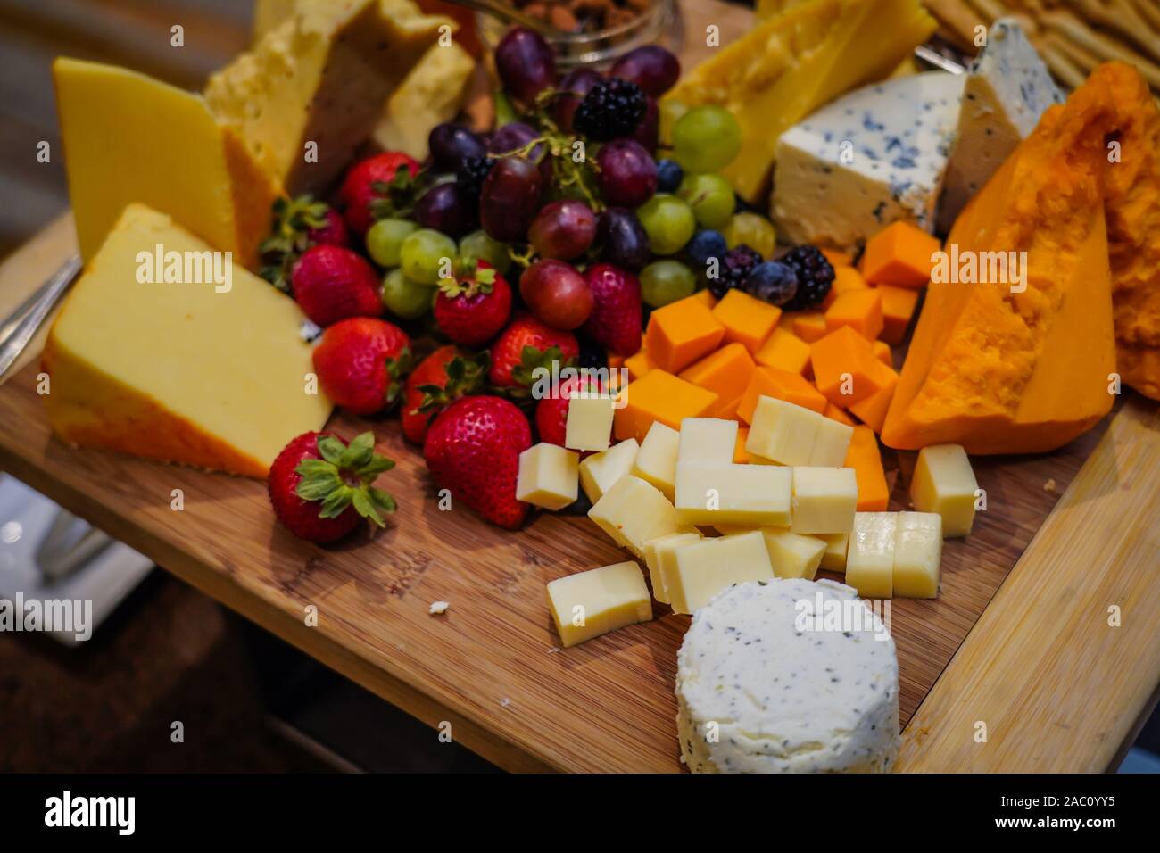 Käseplatte mit verschiedenen Käsesorten und Obst Stockfoto